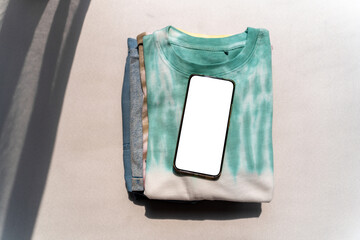 A smartphone with a blank screen on fashionable clothing.