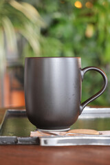 A Stylish Matte Black Coffee Mug Placed on a Beautiful Wooden Table, Perfect for Any Setting