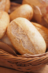 bread rolls rest in a black bowl on the table