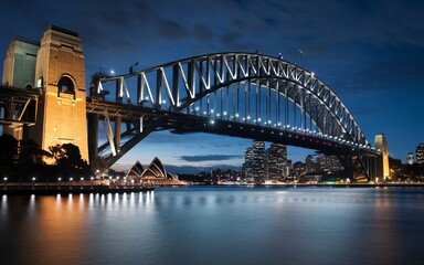 Obraz premium Harbour Bridge at Night: Illuminated Sydney Skyline with Reflections Background