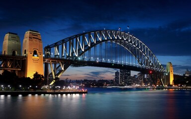 Obraz premium Harbour Bridge at Night: Illuminated Sydney Skyline with Reflections Background