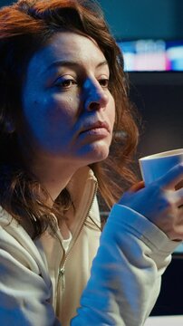 Vertical video Portrait of happy computer engineer enjoying hot tea while implementing security measures to protect company systems and data. Joyful IT worker holding coffee mug and debugging code