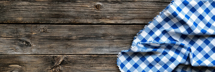 A blue and white checkered tablecloth on a rustic wooden background, generative AI