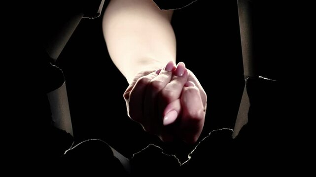 Vertical video. Fig sign. Scam fraud. Female hand teasing with rejection no gesture in black breakthrough paper hole ripped wall on dark night copy space background loop.