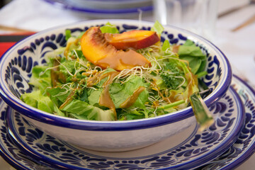 Mexican summer salad with grilled peaches and soy sprouts served on a talavera clay bowl.