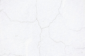 Obraz premium Cracked plaster on an old concrete wall. White wall texture background with thin shabby cracks.