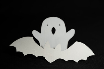 siluetas de papel blanco de murciélago y fantasmita con fondo negro
