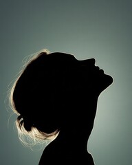A serene silhouette of a woman against a soft, glowing background, representing beauty and elegance in simplicity.