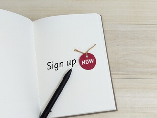 black pen on book with the words sign up now. business  finance