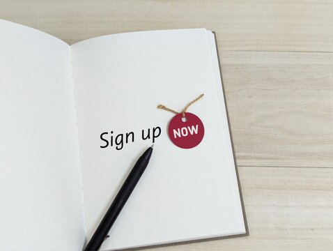 black pen on book with the words sign up now. business finance