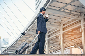 Businessman walking with luggage in business trip. Focus on man legs boarding travel arrival terminal. Business travel trip holding suitcase at airport. Young business man traveller concept