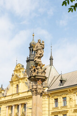 Naklejka premium The top of fountain with plague column is located in public park on Charles Square in old part of Prague in Czech Republic