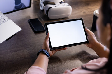 Holding tablet with blank screen, person working in tech office with VR headset, copy space