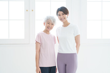 Obraz premium ヨガをするシニア女性とインストラクター