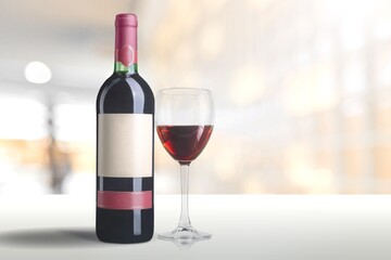 Bottle and glass of alcohol red wine on wall background.