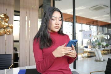 Fototapeta premium Asian woman using smartphone&nbsp;mobile addict spending time checking news social media cell telephone technology e-commerce concept.