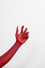 A witch's hand with long red nails on a white background, resembling a demon's or zombie's hand. This scary monster is perfect for Halloween, symbolizing a resurrected fictional creature.