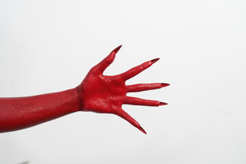 A witch's hand with long red nails on a white background, resembling a demon's or zombie's hand....