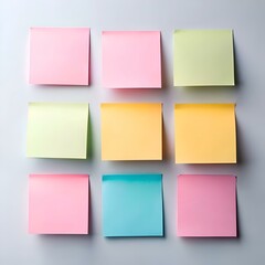 Fototapeta premium A set of nine colorful sticky notes in various hues of pink. yellow. blue. and green arranged in a grid pattern on a white background.