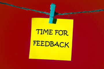 Conceptual time for feedback symbol. Copy space. TIME FOR FEEDBACK words written on a yellow sticker on a red background