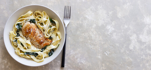 Pasta alfredo with chicken, spinach and cheese. Italian food.