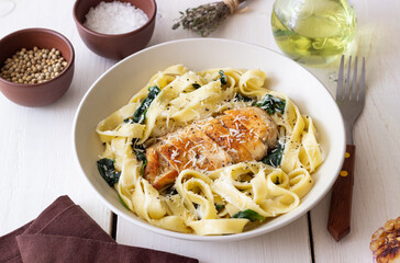 Pasta alfredo with chicken, spinach and cheese. Italian food.