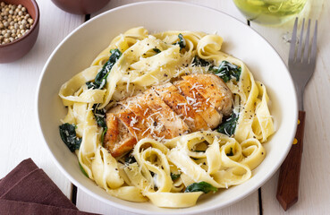 Pasta alfredo with chicken, spinach and cheese. Italian food.