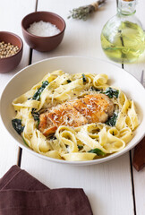 Pasta alfredo with chicken, spinach and cheese. Italian food.