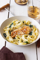 Pasta alfredo with chicken, spinach and cheese. Italian food.