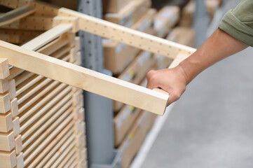 A person is holding wooden frame in store, showcasing craftsmanship and attention to detail.