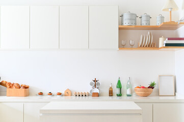 A modern kitchen with clean design featuring shelves, glassware, and fresh produce, creating welcoming atmosphere.