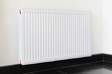 A modern white radiator mounted on wall, providing warmth in stylish interior.