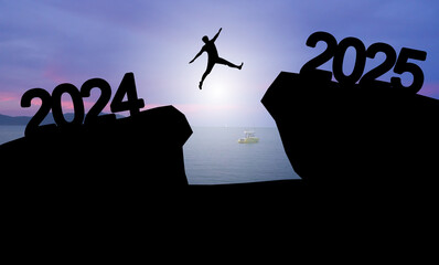 Happy new year 2025 Silhouette image of happy man jump from 2024 up to 2025 on sunset background.