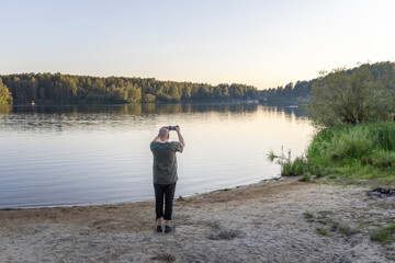Fototapeta premium A man is taking a picture of the lake