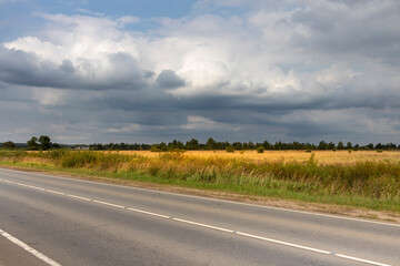 A road with a cloudy sky in the background