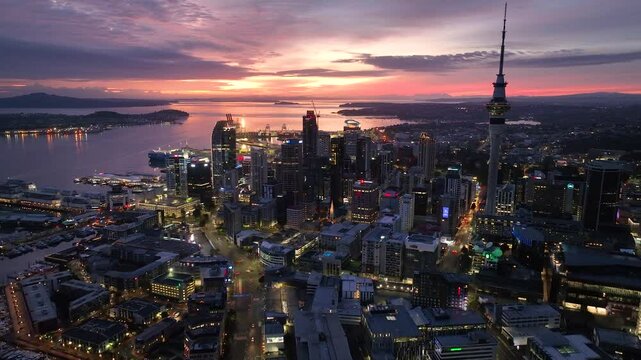 Dolly Flight through Auckland , New Zealand. Skyline. New Skyscrapers. Urban Canyon in Sunset or Sunrise Light. Aerial Pedestal in Establishing Night Drone Shot. Glowing street lights 