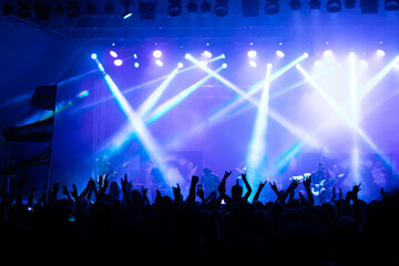 Crowd at concert and colorful stage lights.