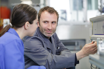 Obraz premium engineer training female apprentice on milling machine