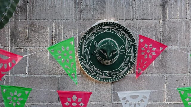 mexican mariachi hat hanging on a wall with decorative pennants
