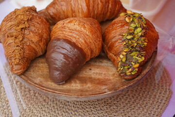 Croissants with different fillings are laid out on a round tray.