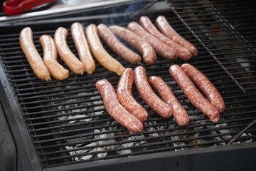 Sausages are fried on the surface of the grill.