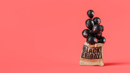 Black friday paper bag full of black balloons with percent symbol on red background