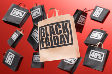 Shopping bags falling with black friday advertising on red background