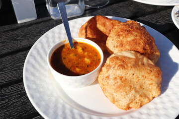 Indian cuisine - Puri Bhaji. It is a traditional breakfast dish in North India. Puri is a deep fried bread made from whole wheat flour and Served with spicy Potato curry called bhaji or alu ki sabji.