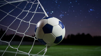 Fototapeta premium Soccer ball hitting the net under starry night sky on a grassy field, representing victory and sportsmanship.