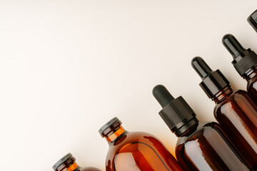 Various Amber Glass Containers for Essential Oils and Skin Care Products Displayed on Light Background