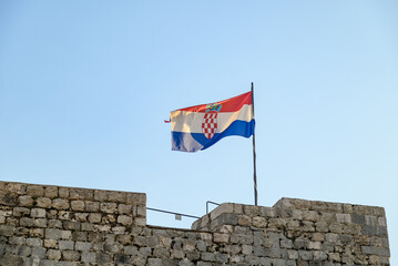 Flag of Croatia atop the walls of the Old Walled City of Dubrovnik, UNESCO world heritage site at...