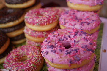 Donuts with different powders and fillings are laid out on top of each other.