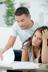 Fototapeta premium worried couple looking through paperwork
