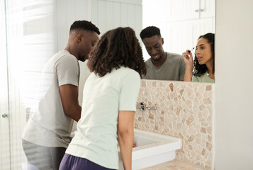 Smiling young multiracial couple getting ready in their bathroom in the morning